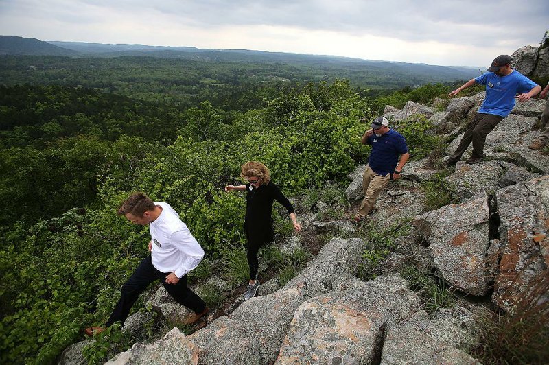 Arkansas Natural Heritage Commission members and guests climb down Wednesday after a dedication ceremony for the Rattlesnake Ridge Natural Area.  
