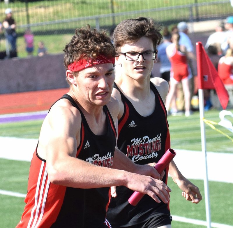 RICK PECK/SPECIAL TO MCDONALD COUNTY PRESS Cole DelosSantos takes a handoff from John Howard during the McDonald County Mustangs' 4x800 relay team's second-place effort at the Monett Relays held on April 24 at Monett High School.
