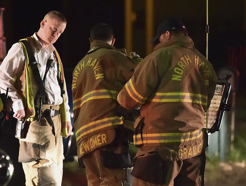 Emergency personnel respond to Quinnipiac Avenue in North Haven, Conn., at the scene of explosion and reported stand-off Wednesday evening, May 2, 2018. A barn behind a house in Connecticut exploded Wednesday night while police and a SWAT team were negotiating with a man who had taken his wife and family hostage, leaving several officers injured, officials said. 