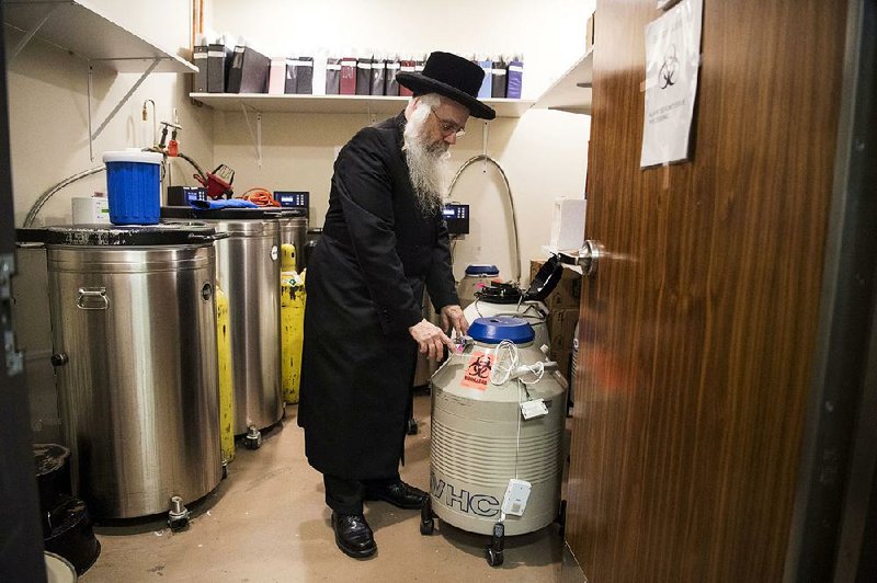 Rabbi Avrohom Friedlander, chief chaplain at Maimonides Medical Center, checks a seal on a nitrogen tank containing frozen eggs and embryos at Genesis Fertility in Brooklyn, N.Y.. “There are a lot of lives in here,” he said. 
