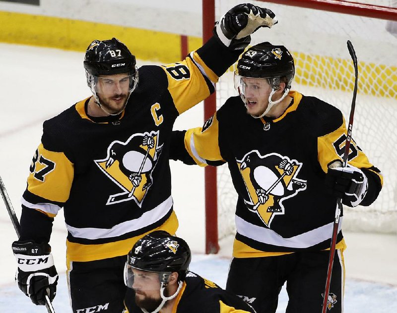 Pittsburgh’s Jake Guentzel (right) celebrates with teammate Sidney Crosby after scoring his second goal Thursday, an empty-netter that gave the Penguins a 3-1 victory over the Washington Capitals in Pittsburgh.  