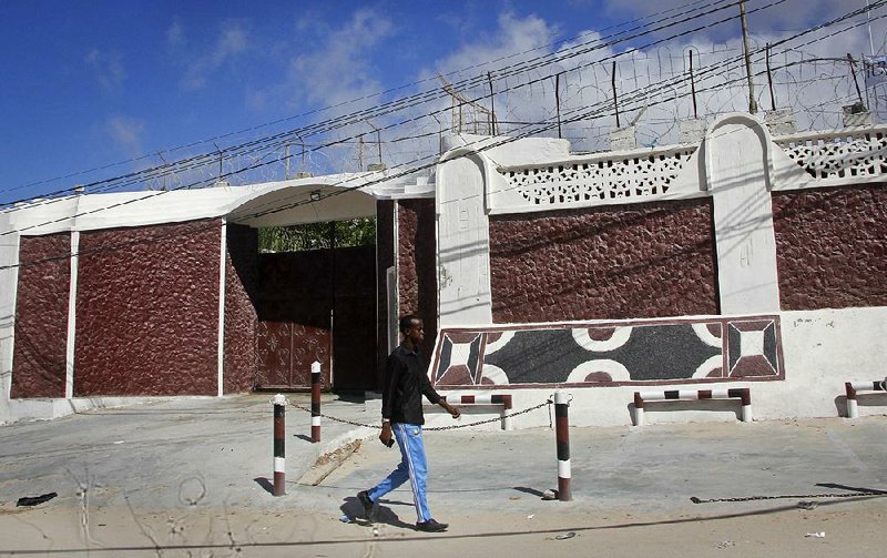 A Somali man walks Thursday past the entrance to the Red Cross compound in Mogadishu, where armed gunmen kidnapped a nurse late Wednesday. 