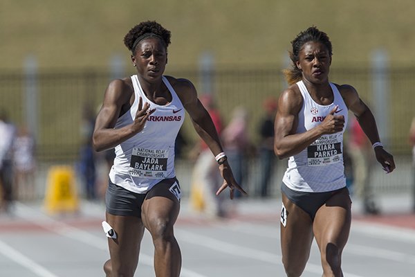 Jada Baylark (left) and Kiara Parker of Arkansas run in the women's 100-meter dash Friday, April 27, 2018, during the National Relay Championships at John McDonnell Field in Fayetteville.
