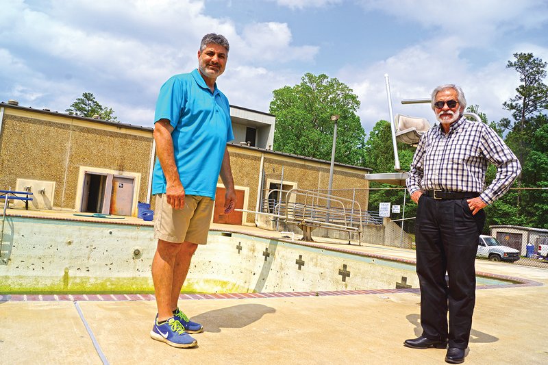 Joel Stanton, left, director of the Sheridan Parks and Recreation Department, and Sheridan Mayor Joe C. Wise Jr. await workers who will refurbish the swimming pool at the Sheridan Community Center. The pool and splash pad will open Memorial Day weekend.