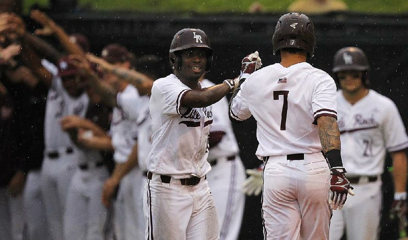 UALR’s Danny Mitchell Jr. (left) congratulates teammate Matt Merino after a third-inning home run Friday against South Alabama at Gary Hogan Field in Little Rock. 