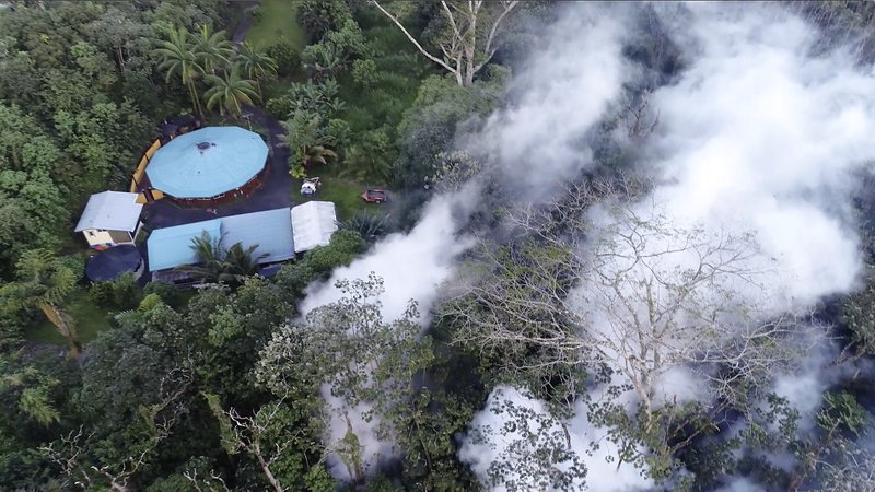 In this still frame taken from video, lava flows toward a home in the Puna District as a result of the eruption from Kilauea Volcano on Hawaii's Big Island, Friday, May 4, 2018. The eruption sent molten lava through forests and bubbling up from paved streets and forced the evacuation of about 1,500 people who were still out of their homes Friday after Thursday's eruption. (Byron Matthews via AP)