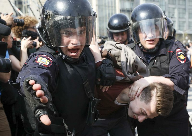 Police officers in Moscow’s Pushkin Square detain a protester Saturday during a demonstration against President Vladimir Putin, who is to be sworn in for his fourth term as president on Monday. 
