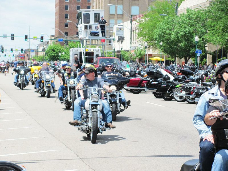 Hundreds of motorcyclists in Fort Smith for the Steel Horse Rally take time to see and be seen Saturday as they travel up and down Garrison Avenue under the watchful eye of police officers.  