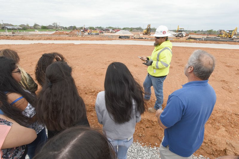 NWA Democrat-Gazette/FLIP PUTTHOFF Students and teachers look Tuesday at the construction site of a new Rogers elementary school guided by Angelo Moreno with Flintco construction company. Female students visited construction sites to learn about careers in the construction industry.