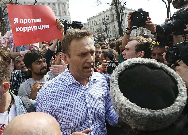 Russian opposition leader Alexei Navalny, center, argues with fighters of National Liberation movement during a demonstration against President Vladimir Putin in Pushkin Square in Moscow, Russia, Saturday, May 5, 2018. 