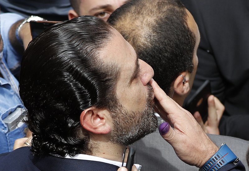 Lebanese Prime Minister Saad Hariri, send kisses to his supporters after he voted for Lebanon's parliamentary elections, outside a polling station, in Beirut, Lebanon, Sunday, May 6, 2018. Lebanon's polling stations have opened for the first parliamentary elections in nine years. (AP Photo/Hussein Malla)