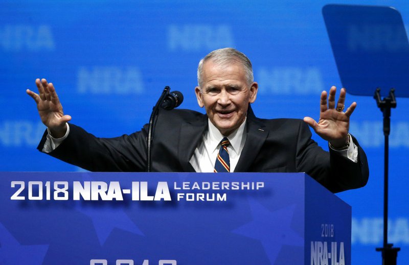 In this May 4, 2018 photo, former U.S. Marine Lt. Col. Oliver North acknowledges attendees as he gives the Invocation at the National Rifle Association-Institute for Legislative Action Leadership Forum in Dallas.   The NRA announced today that North will become President of the National Rifle Association of America within a few weeks, a process the NRA Board of Directors initiated this morning.  (AP Photo/Sue Ogrocki)