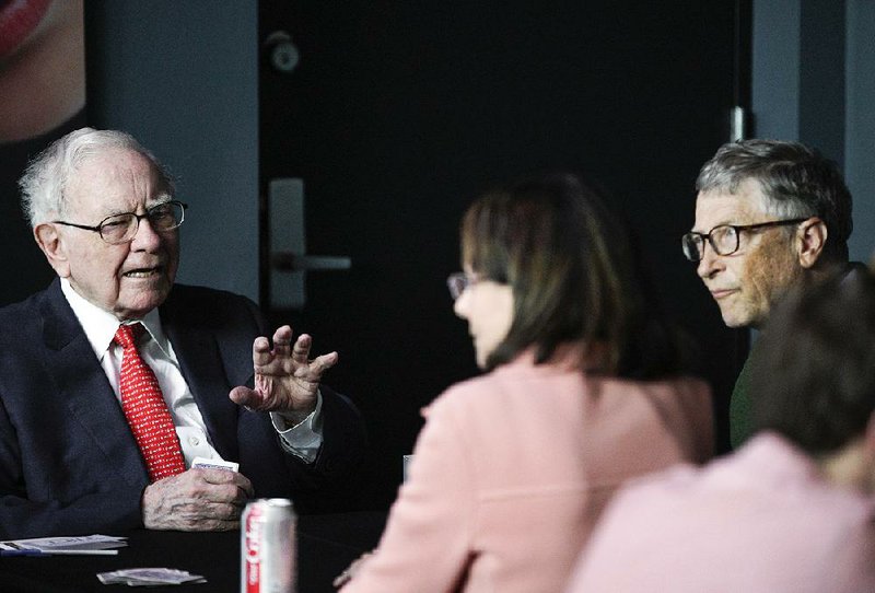 Warren Buffett, chairman and CEO of Berkshire Hathaway (left), talks while playing bridge with Bill Gates (right) outside Berkshireowned Borsheims jewelry store in Omaha, Neb., on Sunday. 
