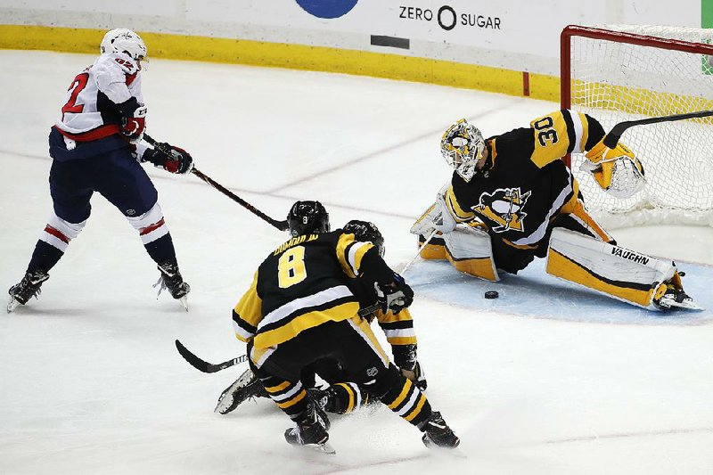 Evgeny Kuznetsov (left) of the Washington Capitals fires the game-winning goal between the pads of Pittsburgh Penguins goaltender Matt Murray in overtime in Game 6 of Monday’s Eastern Conference semifi nals. The Capitals won 2-1 to take the series 4-2. 
