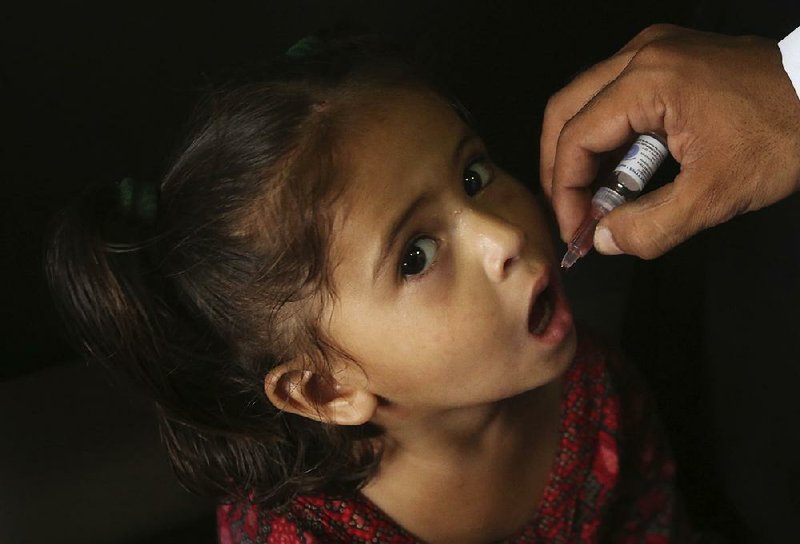 A Pakistani health worker gives a polio vaccine to a girl Monday in Karachi, Pakistan. 