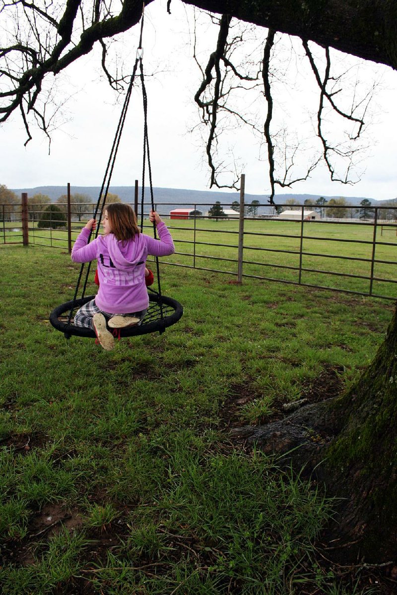 Brooklyn takes a spin on a swing at the ranch, which covers more than 500 acres. 