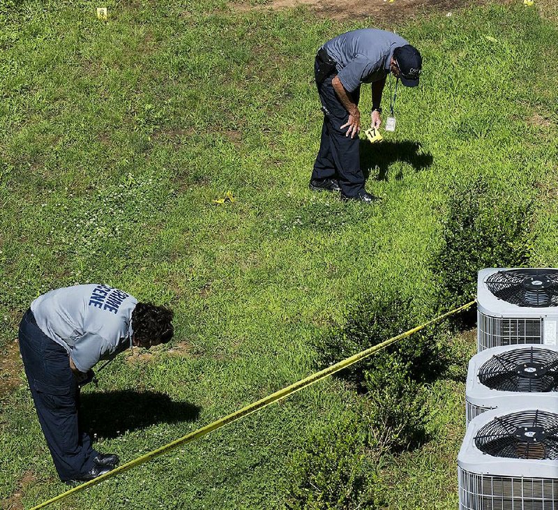 Crime scene investigators search for evidence at the Arkansas River Apartments, 6900 Cantrell Road in Little Rock, on Monday, June 6, 2016. One man was killed and two people were injured in a shooting at the complex.