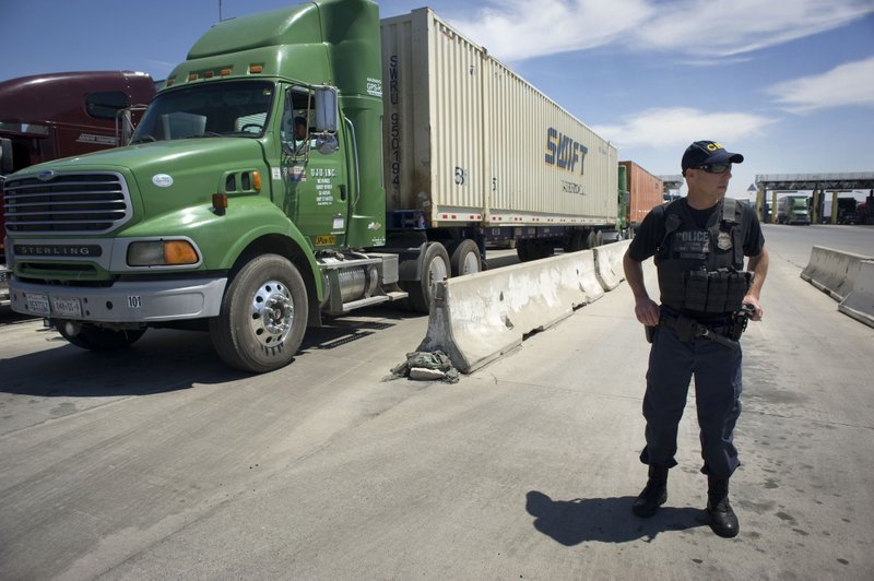 A U.S. Customs and Border Protection (CBP) officer stands next to a line of trucks that will undergo secondary inspection at the Otay Mesa Cargo Port of Entry in San Diego on May 23, 2017. MUST CREDIT: Bloomberg photo by David Maung.