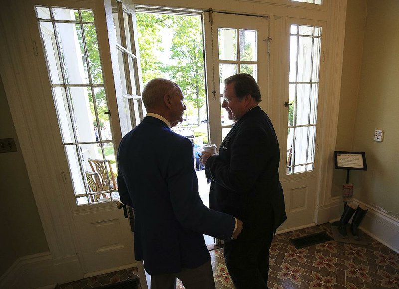 Little Rock Mayor Mark Stodola (right) talks with his predecessor, Jim Dailey, before speaking at a news conference Tuesday at Little Rock’s Curran Hall about National Travel and Tourism Week. Stodola said he will leave office at the end of this year.  