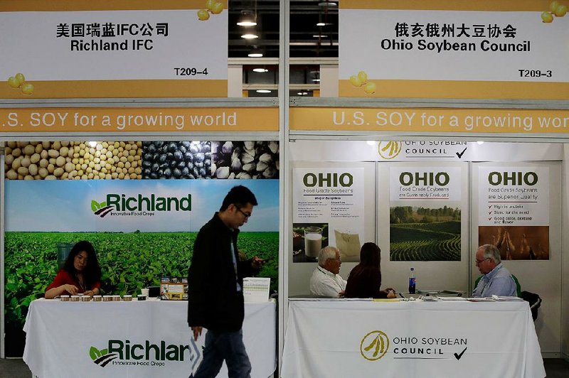 A visitor walks past U.S. soybean companies’ booths at an international soybean exhibition in Shanghai in April.  