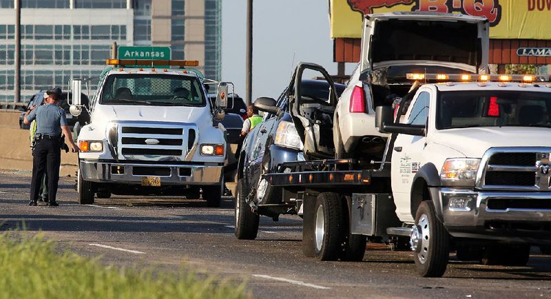 Arkansas State Police and workers clear the wreckage Tuesday after a multiple-car fatal accident in the eastbound lanes of Interstate 30 at the Arkansas River bridge.