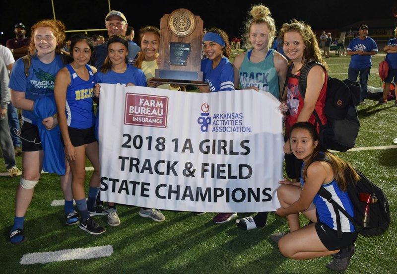Westside Eagle Observer/MIKE ECKELS Members of the Decatur Lady Bulldog track team display their trophy and banner after winning the 1A State Championship at Mineral Springs High School on May 2. Members of the team include Bronwyn Berry (from left), Stephanie Sandoval, Destiny Mejia, Coach Shane Holland (back), Leticia Fuentes, Desi Meek, Paige Vann, Abby Tilley and Deysi Rubi (kneeling). Story on Page B1.