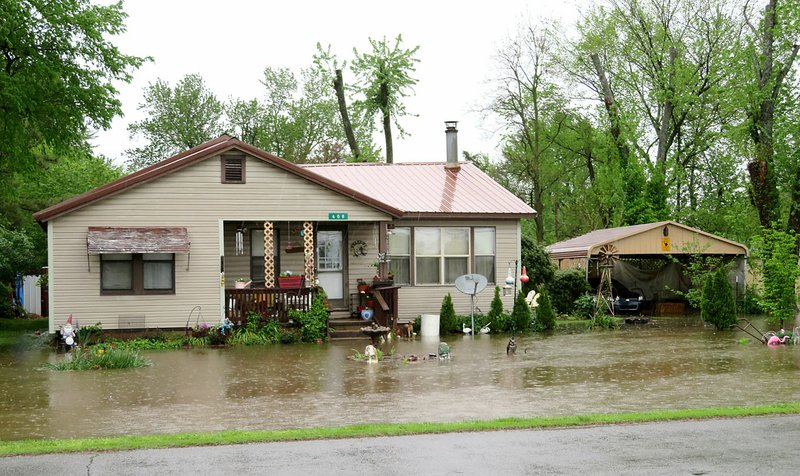 Westside Eagle Observer/RANDY MOLL Heavy rains on Thursday again caused localized flooding of streets and yards in Gentry, as seen at this home on West Main Street in Gentry.