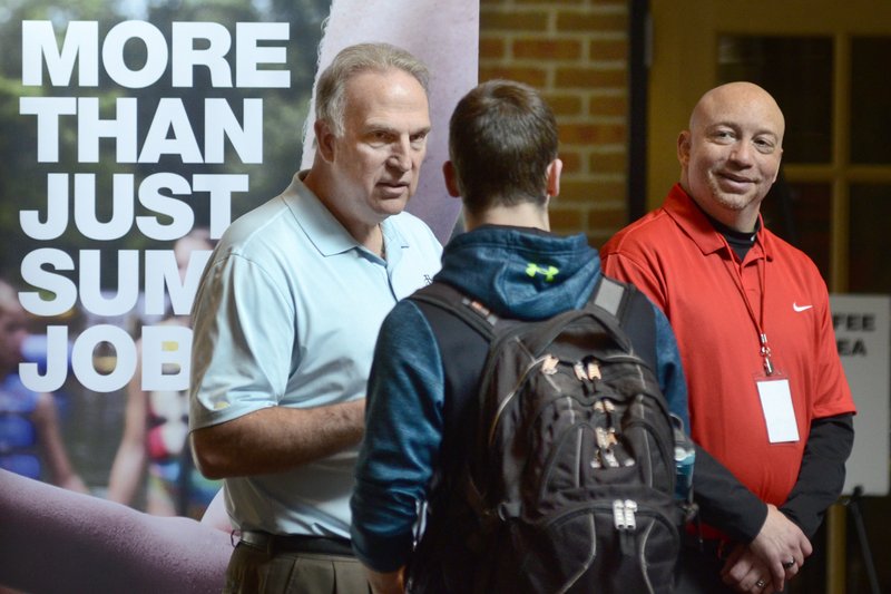 FILE - In this March 14, 2018 file photo, Dan Cieslak, left, a Human Resources representative for the Dunham's Distribution Center, and Warren Whitlow, a training manager, speak to students and other visitors during the Experience Indiana job fair event in the student center at Indiana Wesleyan University in Marion, Ind. U.S. employers advertised 6.6 million open jobs in March, the most on records dating back to December 2000, suggesting businesses want to staff up to meet strong demand. (Jeff Morehead /The Chronicle-Tribune via AP, File)