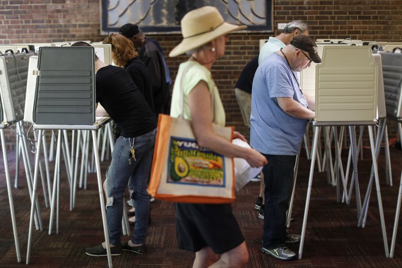 Voters fill out their ballots at the Cincinnati Public Library precinct on primary election day, Tuesday, May 8, 2018, in Cincinnati. Ohio's roller-coaster gubernatorial primary season will be decided Tuesday as Republicans and Democrats vote for their nominees to replace term-limited Republican Gov. John Kasich. (AP Photo/John Minchillo)