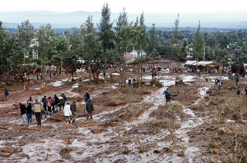 People walk Thursday in an area swept clean by water from a dam burst near Solai, Kenya.  