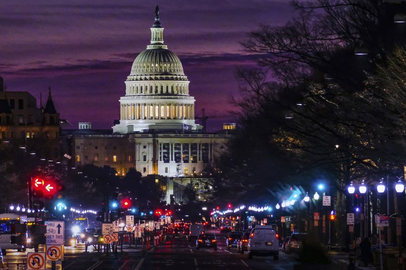 FILE - In Dec. 14, 2016 file photo, early morning traffic rolls down Pennsylvania Avenue toward the U.S. Capitol as daybreaks in Washington.  The federal government swung to a surplus of $214.3 billion in April, 2018 primarily reflecting the revenue from that month's annual tax filing deadline. The Treasury Department reports that last month's surplus increased 17.4 percent from a year ago. (AP Photo/J. David Ake, File)