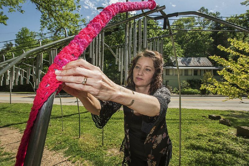 Crochet artist Gina Gallina of the Eureka Yarn Bombs works at a park Friday in Eureka Springs. The art installation replaces one that was vandalized. 
