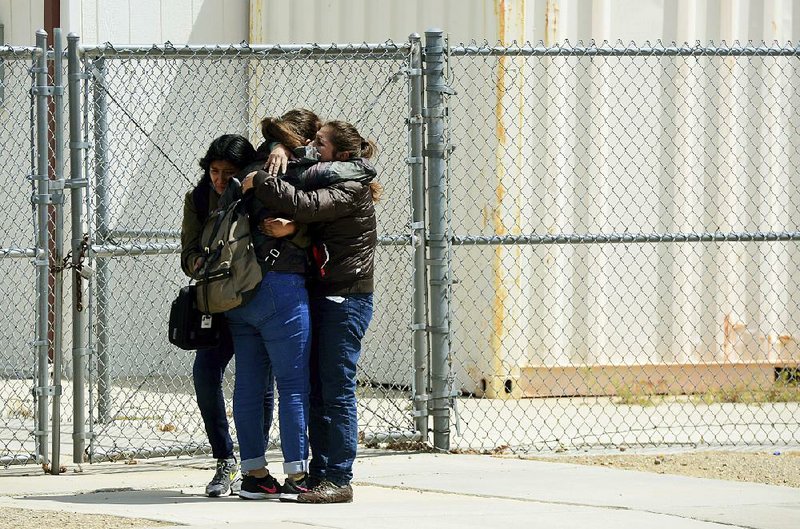 Victoria Aquino hugs her two daughters, Melany, 17 and Halie, 11, after a lockdown was lifted at Highland High School in Palmdale, Calif., after a shooting Friday. 
