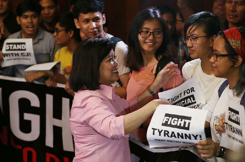 Maria Lourdes Sereno, the ousted Philippines Supreme Court chief justice, greets supporters Friday in Manila. 
