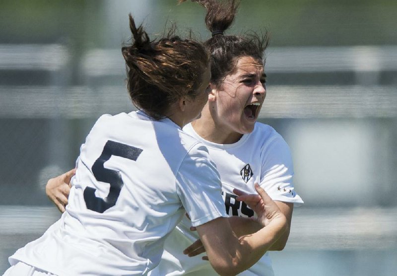 Bentonville’s Tyler Ann Reash (right) and Anna Passmore celebrate after Reash scored the winning goal to lift the Lady Tigers over Mount St. Mary 2-1 on Friday in the Class 7A state tournament quarterfinals at Rogers High School. Bentonville advances to a 10 a.m. semifinal match today against Bryant.  