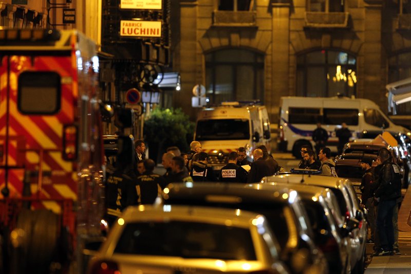 A police officer helps evacuating residents after a knife attack in central Paris, Saturday May 12, 2018. The Paris police said the attacker was subdued by officers during the stabbing attack in the 2nd arrondissement or district of the French capital Saturday. (AP Photo/Thibault Camus)