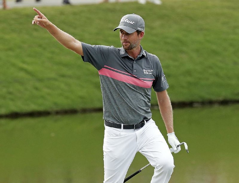 Webb Simpson points to fans after making an eagle on the 11th hole in the third round of The Players Championship. Simpson shot a 68 on Saturday and leads by seven strokes entering today’s final round. 