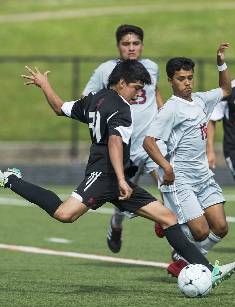 Diego Hernandez (left) of Fort Smith Northside takes a shot on goal as Irvin Sotero of Springdale defends during Northside’s 2-1 victory during the Class 7A semifi nals on Saturday. Northside will meet Rogers in the Class 7A state championship. 
