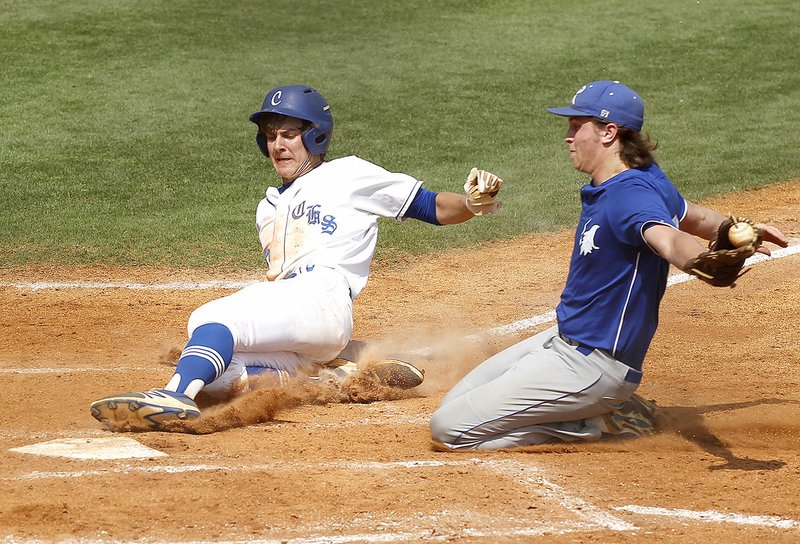 Conway’s Cade White (left) slides into home plate Saturday ahead of a tag from Rogers High pitcher Mason Griffin during the Class A state semifinal at Burns Park in North Little Rock. 