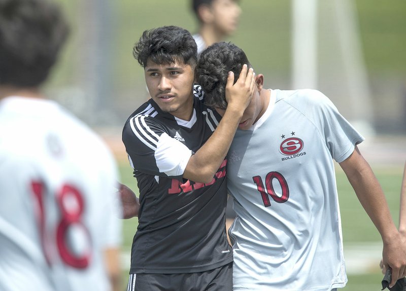 Luis Paredes (left) of Fort Smith Northside embraces Jose Vega of Springdale High after Northside’s victory Saturday in the Class 7A state semifinal match at Gates Stadium in Rogers. 