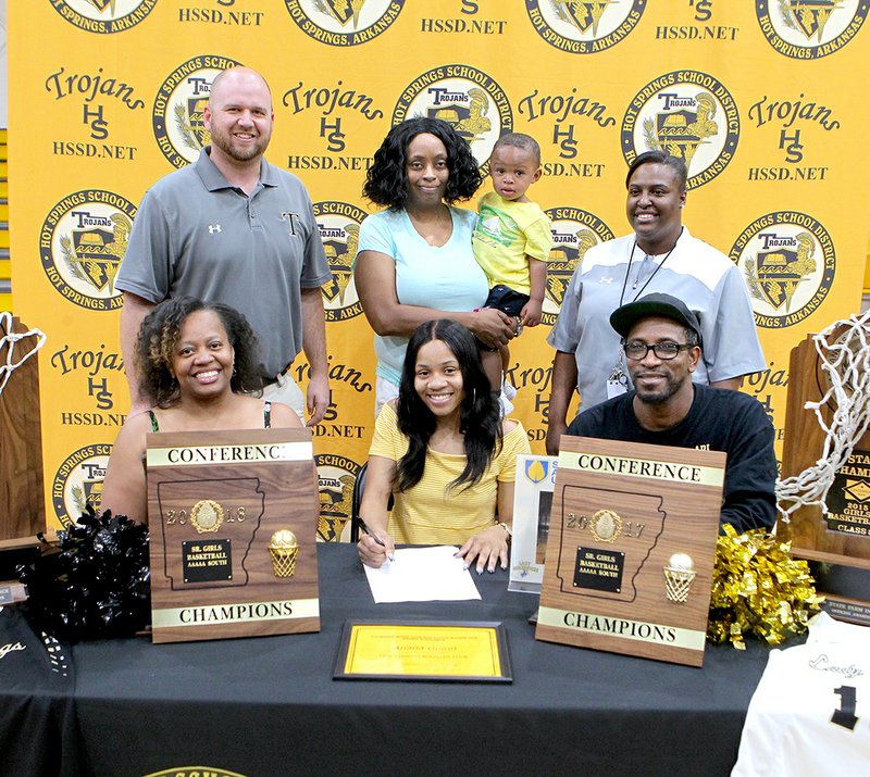 The Sentinel-Record/Richard Rasmussen Hot Springs senior Ariana Guinn, front center, signed her national letter of intent on Friday at Trojan Fieldhouse to play college basketball for Southern Arkansas University in Magnolia. With Guinn, in front, are Tashiba Banks, left, and her step-father James Banks, and back, from left, Hot Springs head coach Josh Smith, her aunt Loretta Denton, her cousin Ayden Payne and assistant coach Nikki Natt. Honey was recently selected to the Arkansas High School Coaches Association all-star basketball roster after averaging 18.9 points, 2.5 rebounds and two assists per game as the Lady Trojans went 31-3, won the 5A-South conference championship for the second year in a row and won the Class 5A state championship at Bank of the Ozarks Arena. Guinn and teammate Imani Honey were named The Sentinel Record's 2018 Girls Basketball Co-Players of the Year and First Team All-Garland County. Smith was selected as The Sentinel-Record's All-Garland County 2018 Winter Sports Girls Coach of the Year.