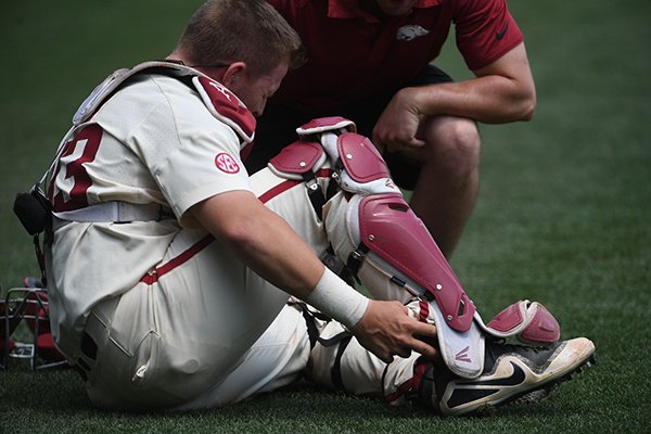 Arkansas catcher Grant Koch reaches for his ankle during the seventh inning of a game against Texas A&M on Sunday, May 13, 2018, in Fayetteville. 