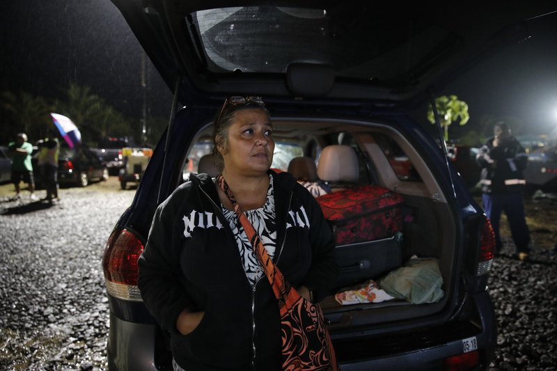  In this May 8, 2018, file photo, evacuee Nina Bersamina, an elementary school teacher, stands next to her SUV loaded with her belongings while waiting to pick up some food at a makeshift donation center in Pahoa, Hawaii. "It's heartbreaking. It's heartbreaking because this is our home," said Bersamina. (AP Photo/Jae C. Hong, File)