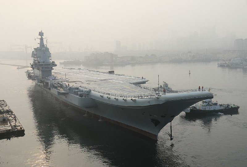 China’s new aircraft carrier leaves the Dalian port for sea trials Sunday in this photo provided by the state-run Xinhua News Agency.
