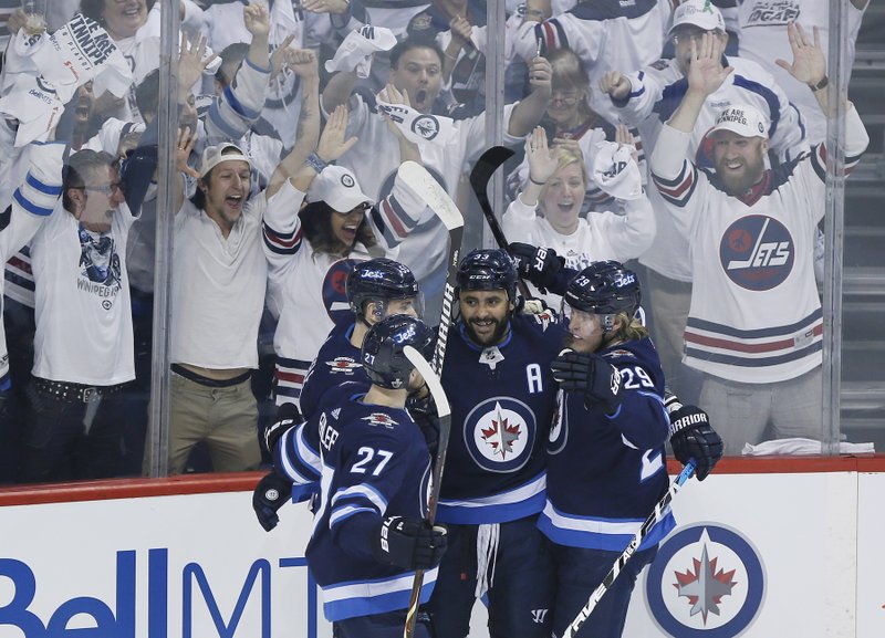 Winnipeg Jets' Nikolaj Ehlers (27), Mark Scheifele (55), Dustin Byfuglien (33) and Patrik Laine (29) celebrate Byfuglien's goal against the Vegas Golden Knights during the first period of Game 1 of the NHL hockey playoffs Western Conference final, Saturday, May 12, 2108, in Winnipeg, Manitoba. (John Woods/The Canadian Press via AP)