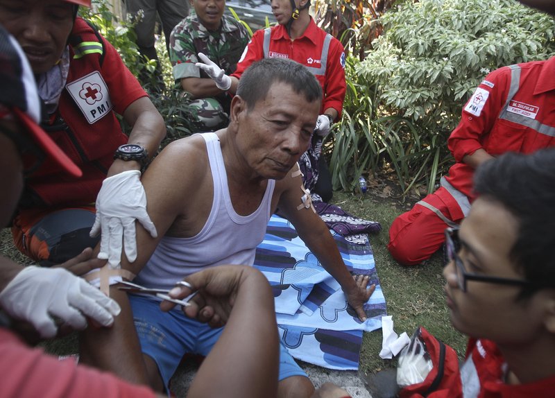 Paramedics tend to a man injured in a church explosion in Surabaya, East Java, Indonesia, Sunday, May 13, 2018. Almost simultaneous attacks including one by a suicide bomber disguised as a churchgoer targeted churches in Indonesia's second largest city of Surabaya early Sunday, killing a number of people and wounding dozens, police said. (AP Photo/Trisnadi)