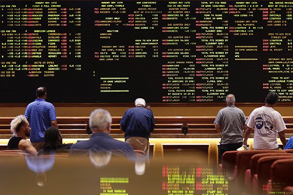 People line up to place bets in the sports book at the South Point hotel-casino, Monday, May 14, 2018, in Las Vegas. The Supreme Court on Monday gave its go-ahead for states to allow gambling on sports across the nation, striking down a federal law that barred betting on football, basketball, baseball and other sports in most states. (AP Photo/John Locher)