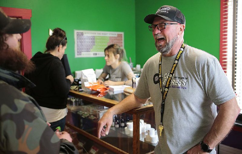 Loren Kruesi (right), owner of CBD Express, talks with a customer last month during the store’s grand opening in Salem, Ore. The business sells cannabidiol oils and other products containing the hemp extract. 
