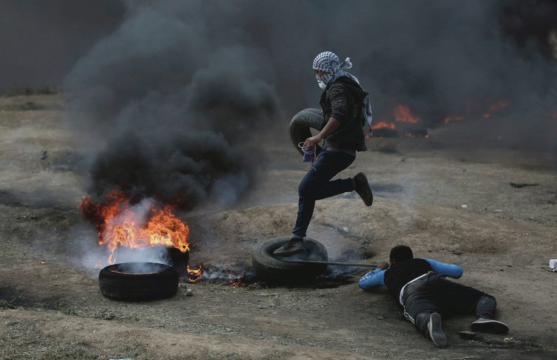 Palestinian protesters burn tires during a protest on the Gaza Strip's border with Israel, Monday, May 14, 2018. Thousands of Palestinians are protesting near Gaza's border with Israel, as Israel prepared for the festive inauguration of a new U.S. Embassy in contested Jerusalem. (AP Photo/Khalil Hamra)