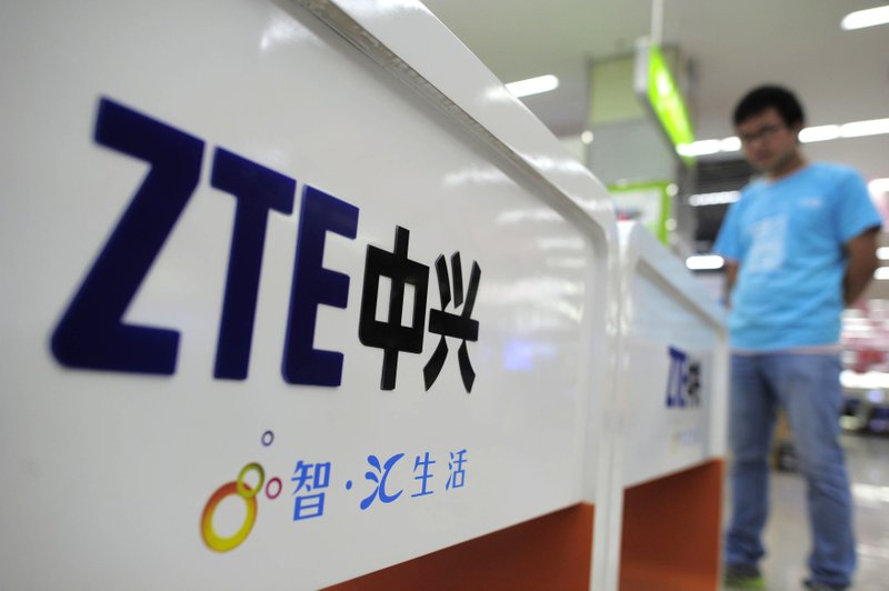 FILE - In this Oct. 8, 2012, file photo, a salesperson stands at counters selling mobile phones produced by ZTE Corp. at an appliance store in Wuhan in central China's Hubei province. (Chinatopix Via AP, File)
